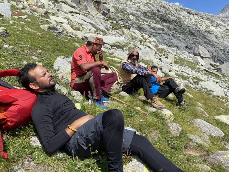 a group of men sitting on a hill