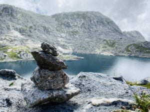 a stack of rocks on a rock by a lake