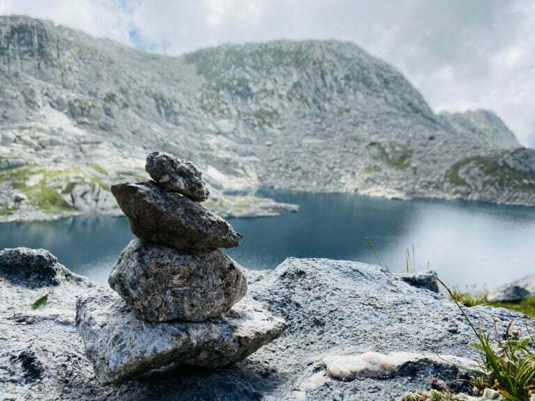 Home 15 Stone cairn beside a high-altitude alpine lake on the Seven Lakes Trek in the Dhauladhar range near Dharamshala