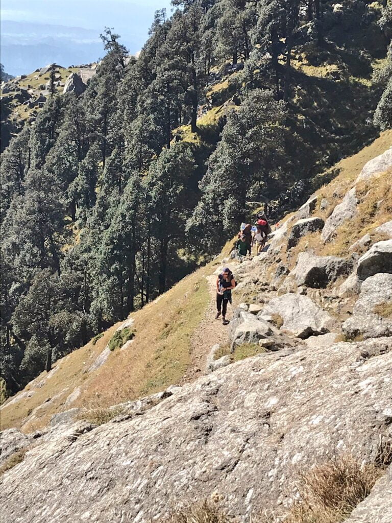 Group of trekkers hiking on a rocky Himalayan trail on a mountain route in Dharamshala