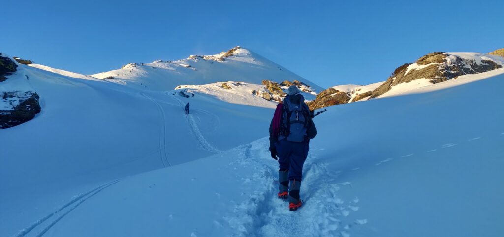 Trekker walking on a snow-covered trail during the Kedarkantha trek in Uttarakhand