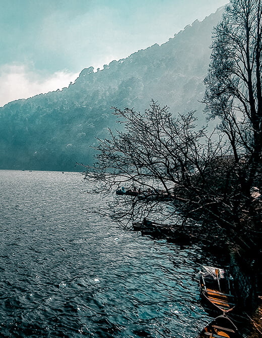 Nainital Lake surrounded by misty hills and pine forests in Uttarakhand, a popular hill station in the Indian Himalayas