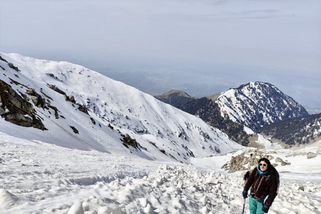Trekker ascending a snow-covered slope on the Indrahar Pass Trek in the Dhauladhar Range near Dharamshala