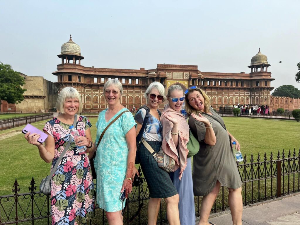 International tourists posing in front of Agra Fort during a sightseeing tour in Agra, India