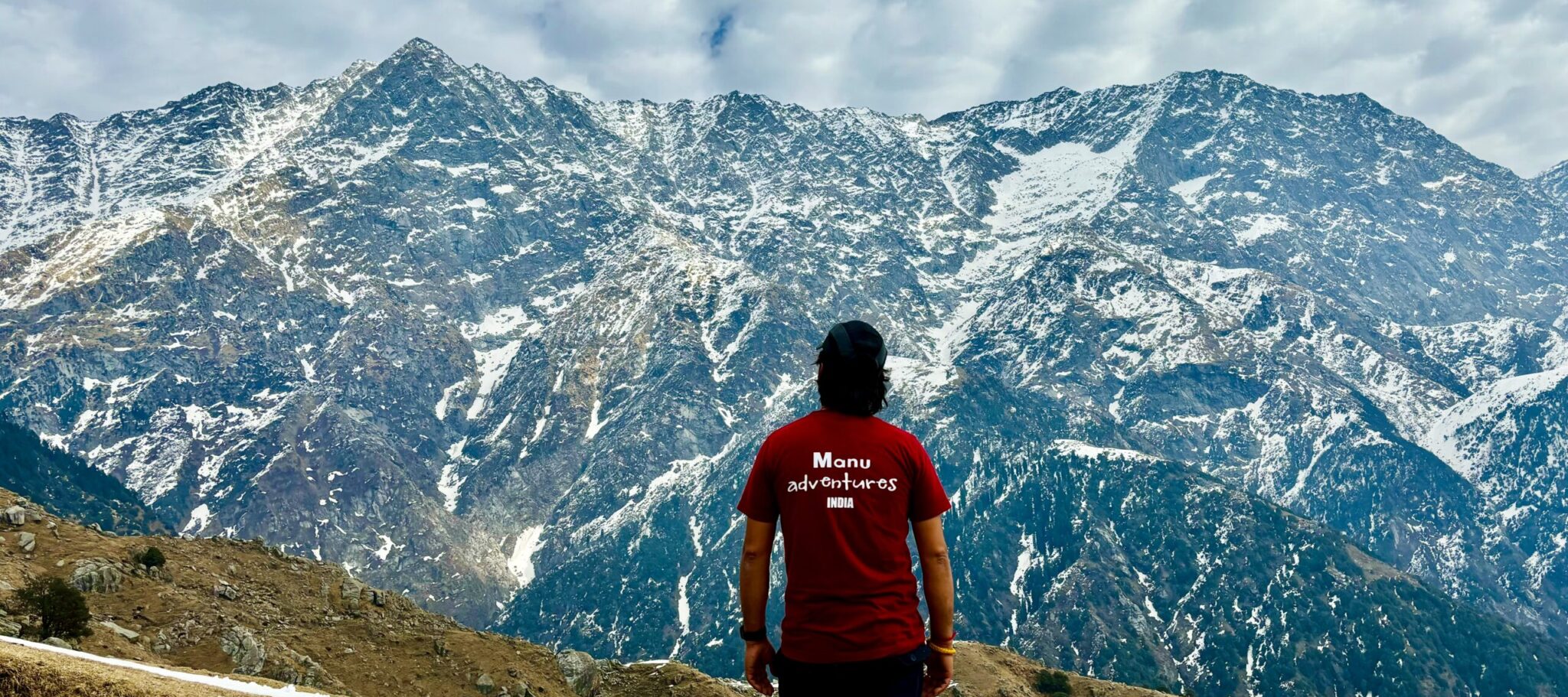 Triund Trek 1 Trekker at Triund overlooking the snow-covered Dhauladhar mountains