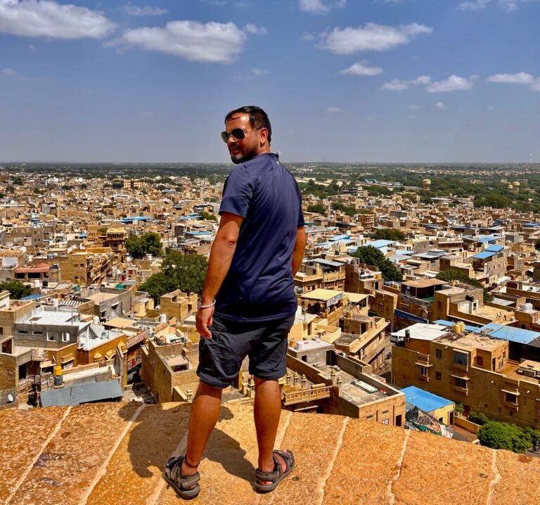Traveler overlooking Jaisalmer city from Jaisalmer Fort with golden sandstone houses, Rajasthan