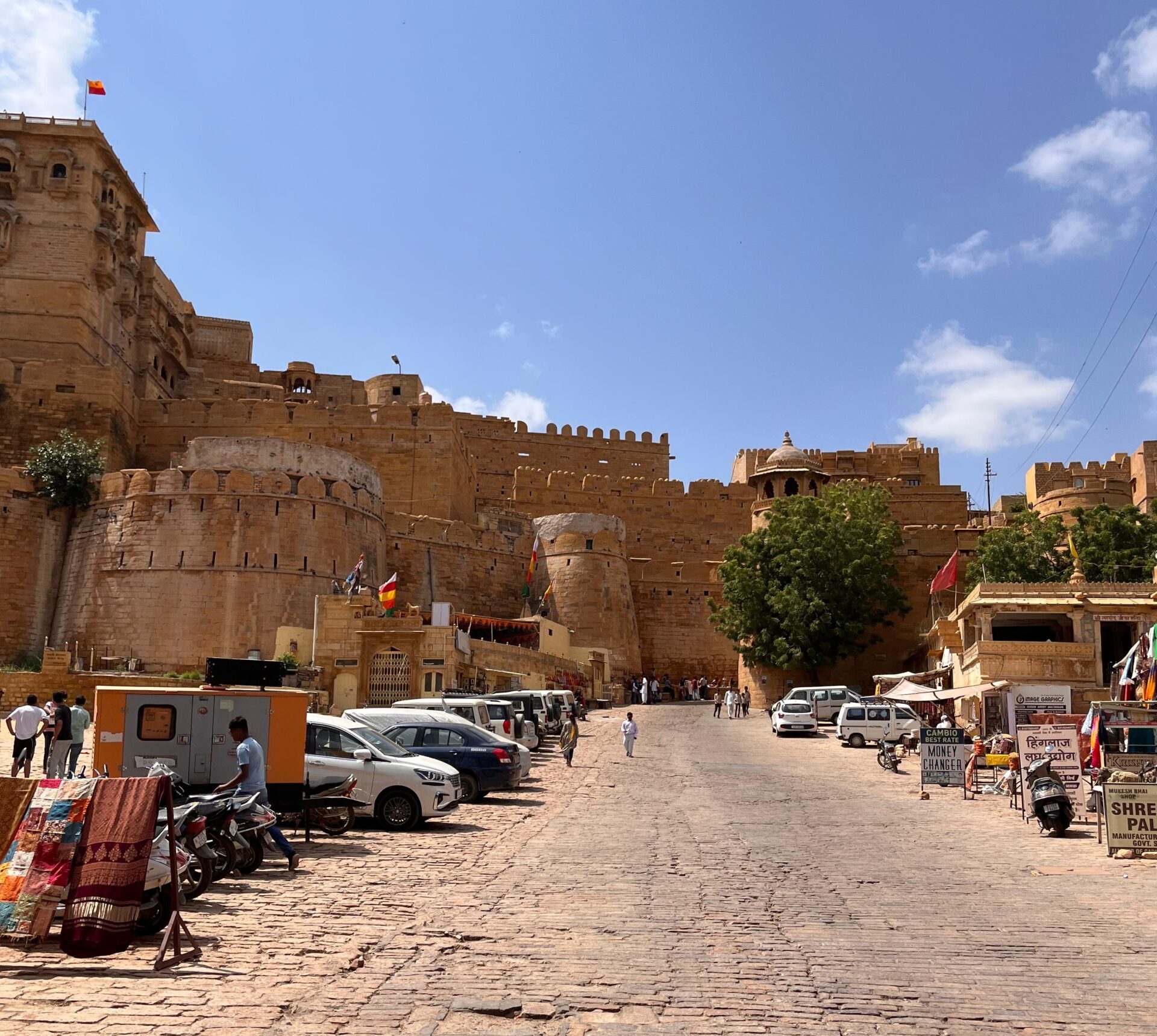 Entrance street of Jaisalmer Fort in Rajasthan with golden sandstone walls, cobblestone road, shops, and visitors