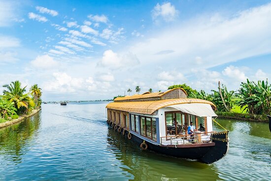 Traditional houseboat cruising through the serene Alleppey backwaters in Kerala