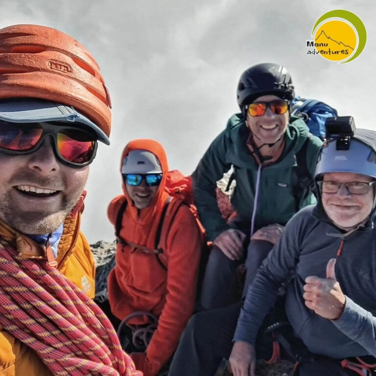 Climbers celebrating on the summit of Mun Peak in the Dhauladhar range near Dharamshala, Himachal Pradesh.