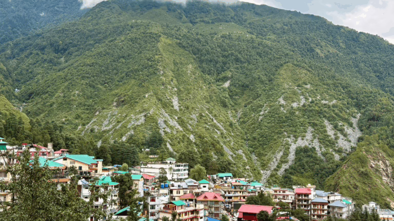 Bhagsunag village in Dharamsala with colorful houses and lush green mountains in the background