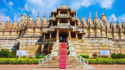 Intricately carved Indian temple with ornate architecture and vibrant steps leading to the entrance.
