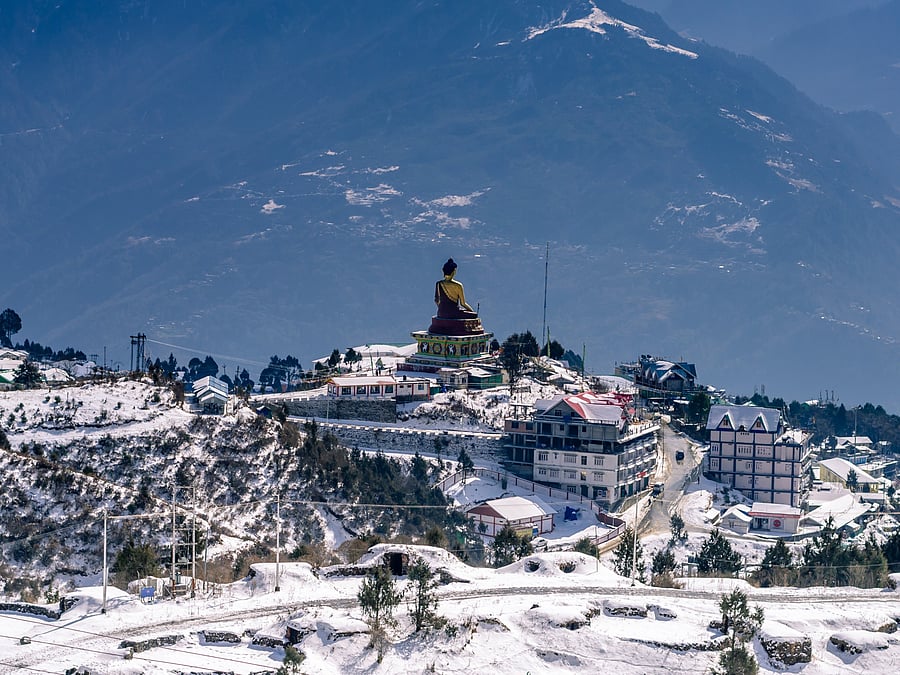 Snow-covered mountain road with rocky slopes and bright blue sky in a winter landscape.