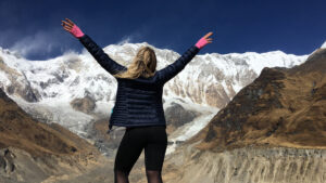 Female solo traveler trekking in the Indian Himalayas with a guided group trek, enjoying safe and scenic mountain trails in Himachal Pradesh.