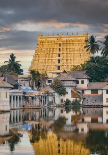 a body of water with buildings and trees with Padmanabhaswamy Temple in the background