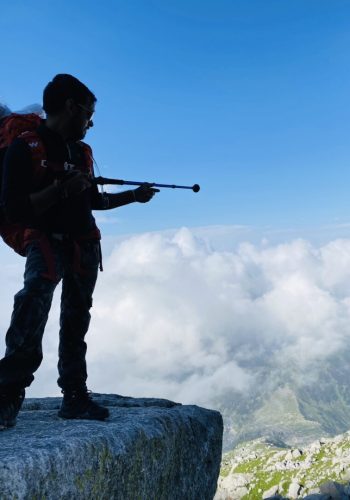 a man standing on a rock holding a rifle