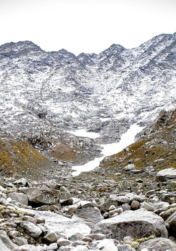 a rocky mountain with snow on the top