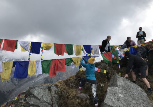 a group of people climbing a rope with flags