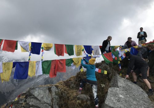 a group of people climbing a rope with flags