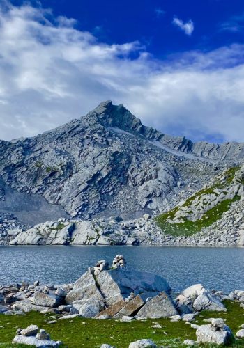 a lake with rocks and mountains in the background